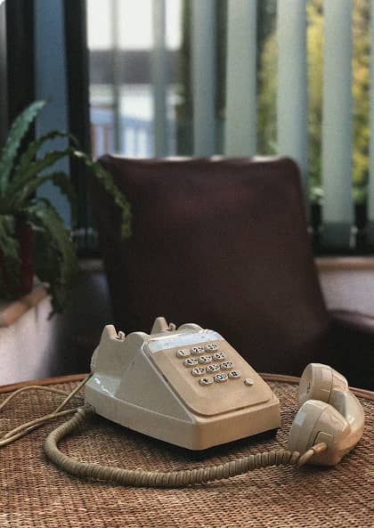 white telephone on a wooden table